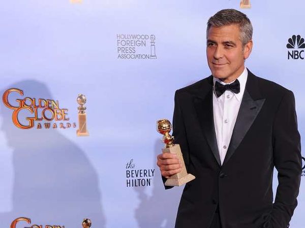 George Clooney com um de seus Globos de Ouro (photo by latimesblogs.latimes.com)