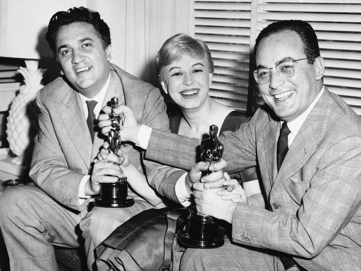Da esquerda para a direita: Federico Fellini, sua esposa e atriz Giulietta Masina e o produtor Dino De Laurentiis com seus Oscars por A Estrada da Vida (photo by businessinsider.com)